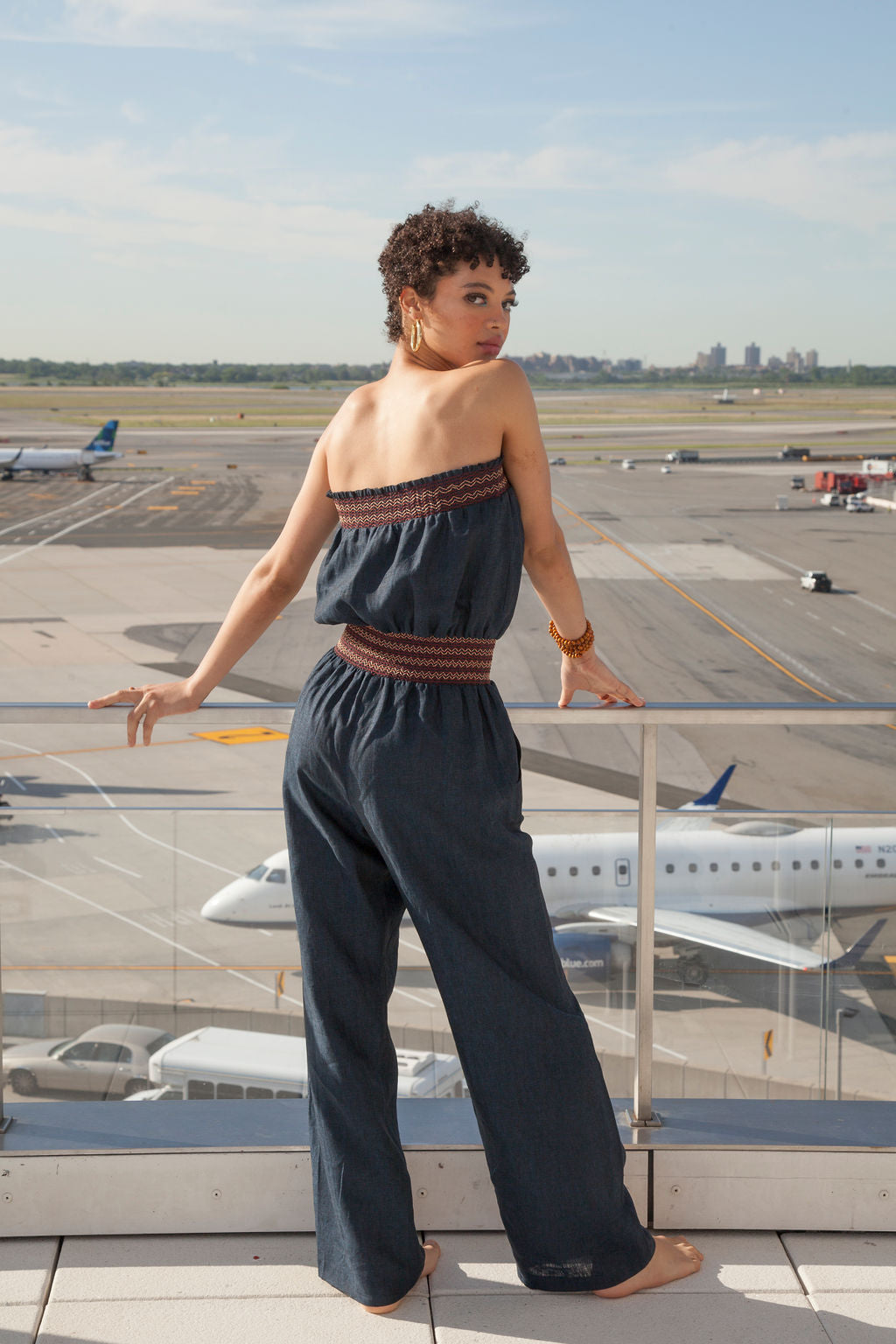 a woman in a romper over looks an airport runway