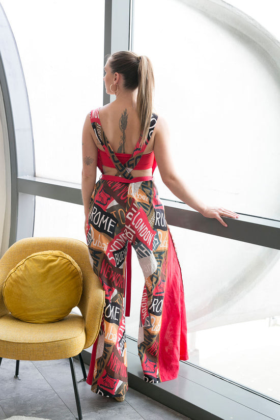 a woman in a romper stands next to a window