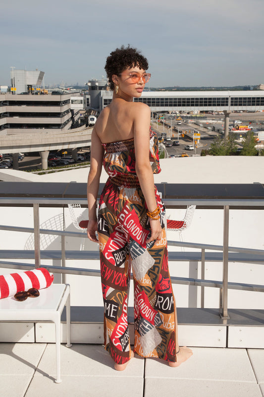 a woman in a romper stands on a balcony